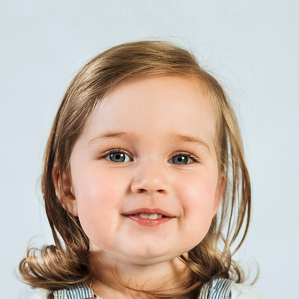 A little girl with long hair, smiling sweetly at the camera, her expression warm and inviting.