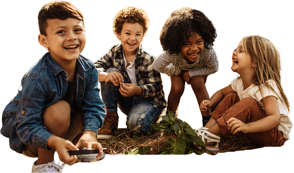 Four children laughing and playing outdoors, displaying joy and friendship